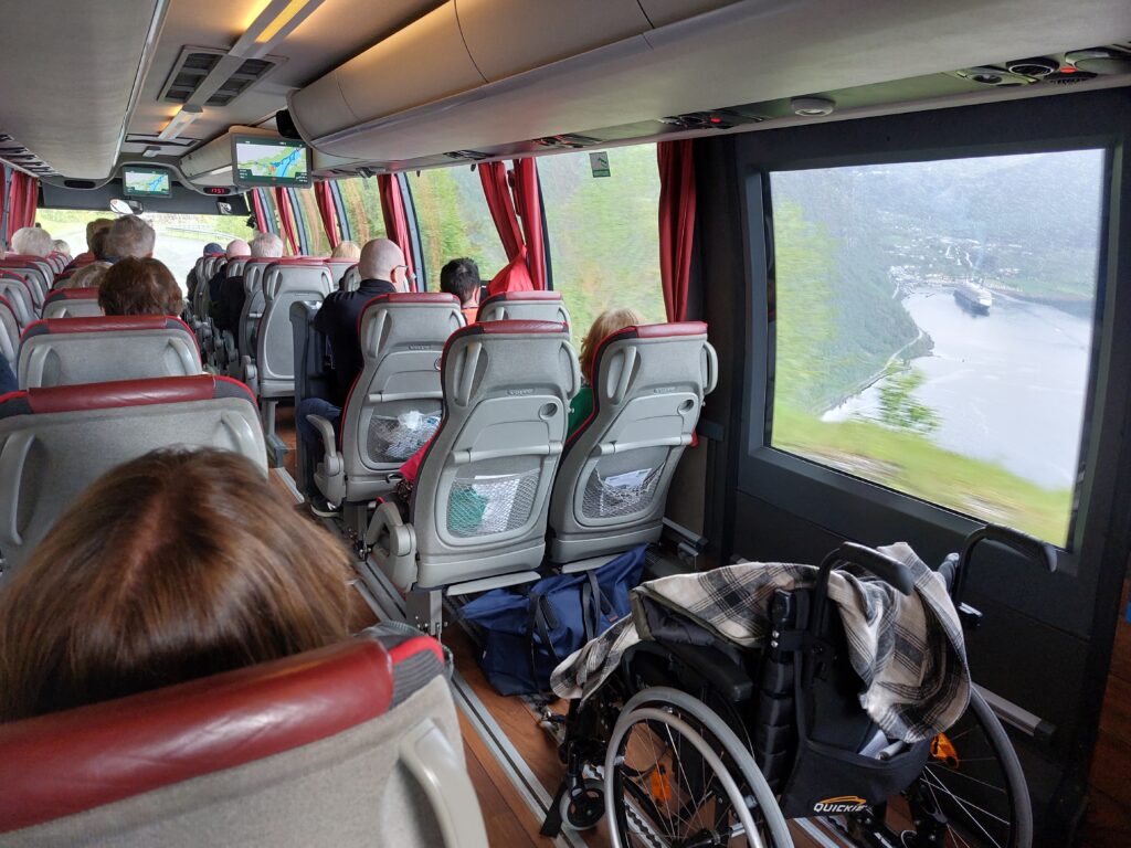 Gjest i rullestol om bord i turbussen med fjordutsikt